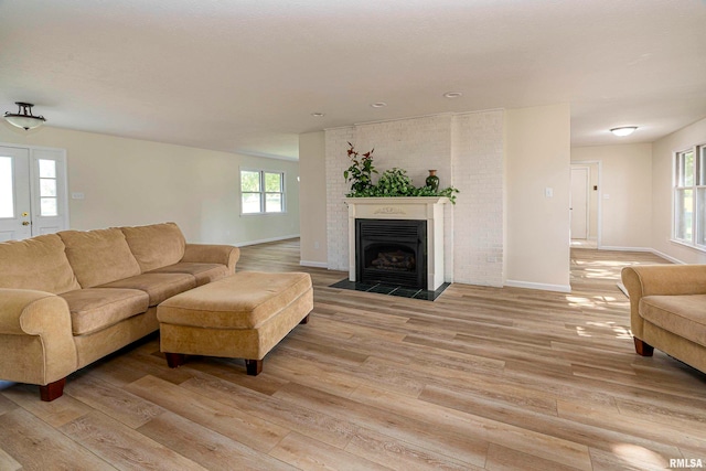 living room with light hardwood / wood-style floors and a healthy amount of sunlight