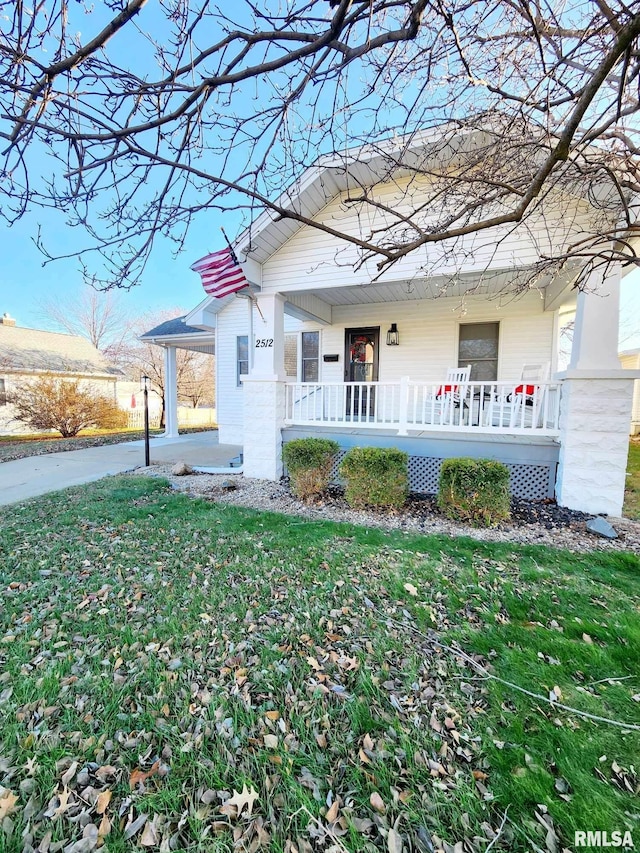 view of front of home with covered porch and a front lawn