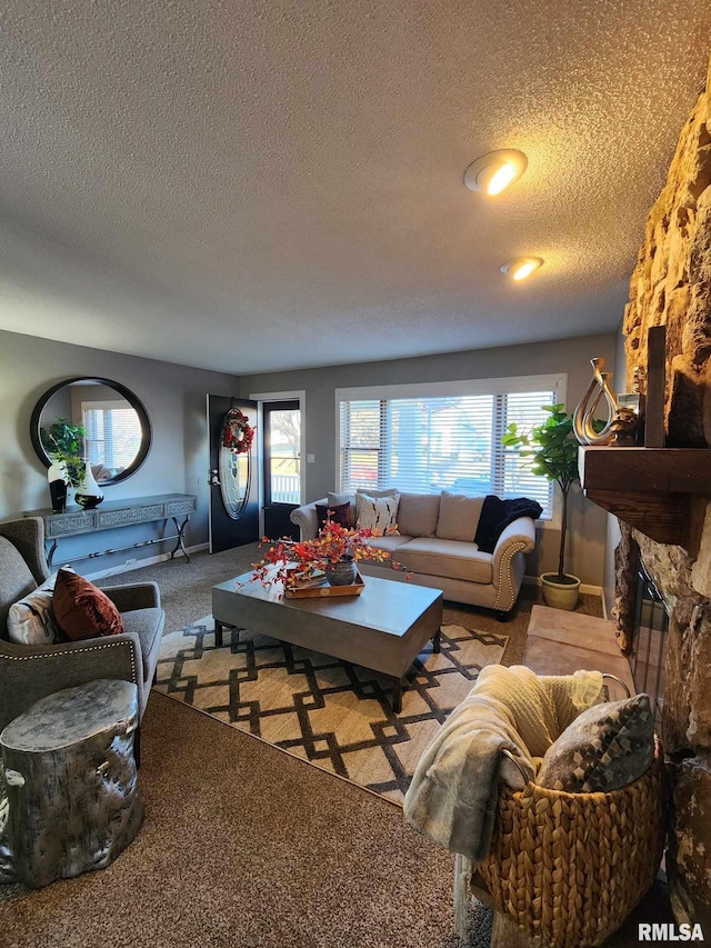 living room with carpet flooring, a textured ceiling, and a fireplace