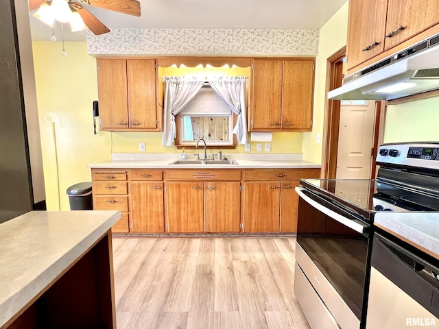 kitchen featuring ceiling fan, appliances with stainless steel finishes, sink, and light hardwood / wood-style flooring