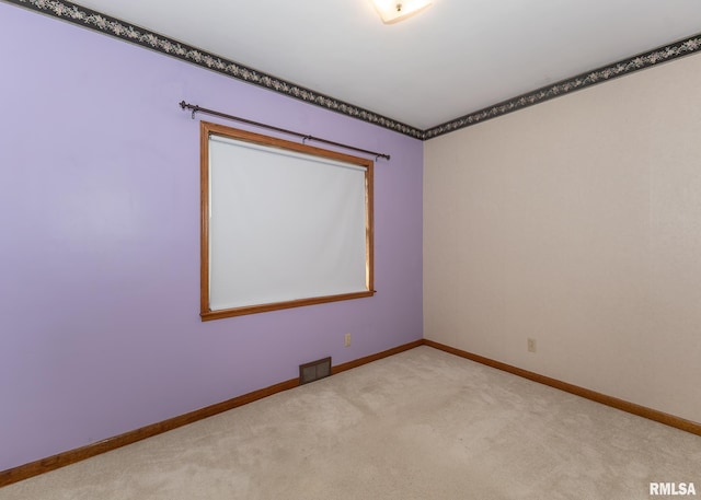 spare room featuring light colored carpet