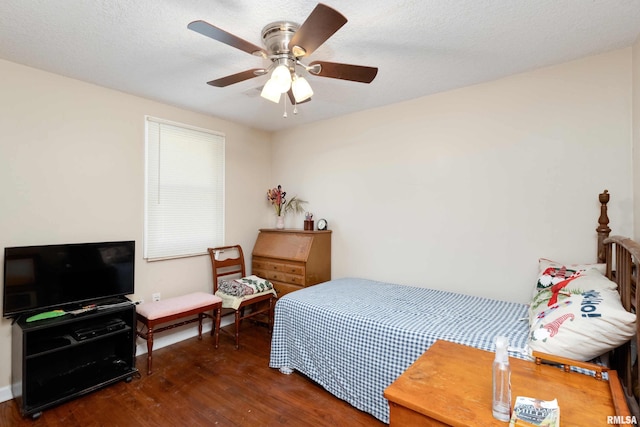 bedroom featuring ceiling fan, a textured ceiling, and dark hardwood / wood-style flooring