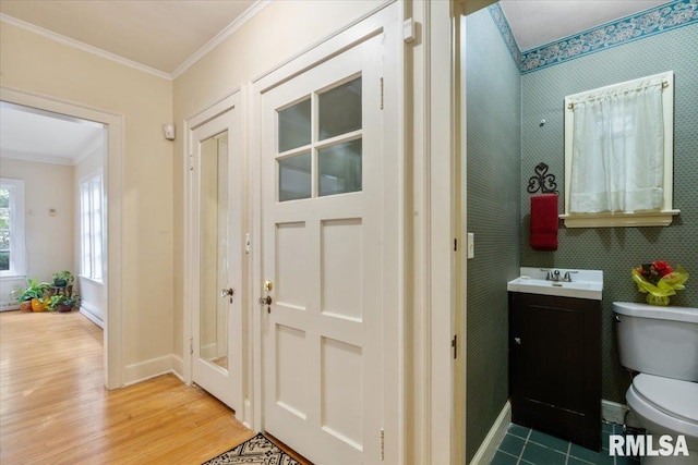 bathroom with wood-type flooring, crown molding, vanity, and toilet