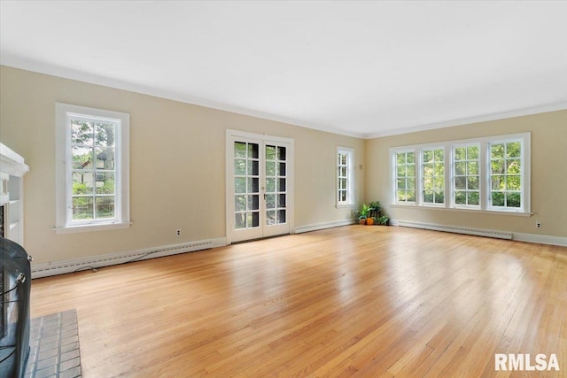 unfurnished living room featuring a fireplace, light wood-type flooring, baseboard heating, and crown molding