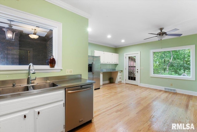 kitchen featuring light hardwood / wood-style floors, white cabinets, stainless steel appliances, ceiling fan, and sink