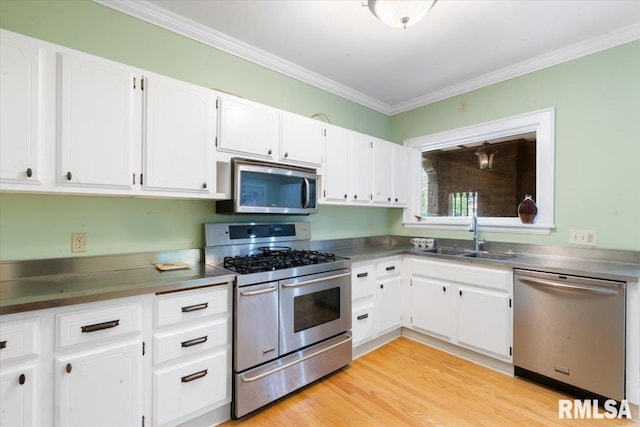 kitchen with sink, white cabinetry, appliances with stainless steel finishes, crown molding, and light hardwood / wood-style floors