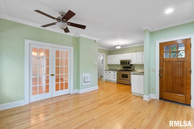 kitchen featuring white cabinetry, light hardwood / wood-style flooring, appliances with stainless steel finishes, ornamental molding, and ceiling fan