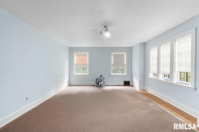 carpeted spare room featuring a healthy amount of sunlight