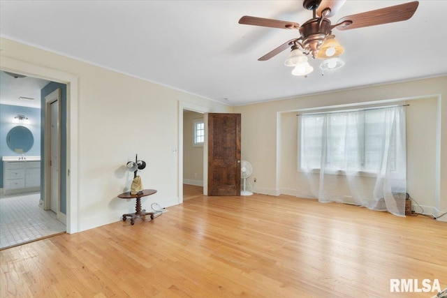 spare room with ceiling fan, ornamental molding, light hardwood / wood-style floors, and a wealth of natural light