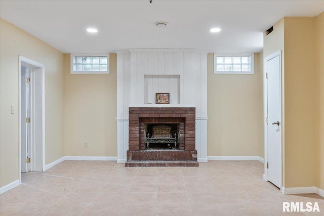 unfurnished living room featuring light tile patterned floors and a brick fireplace