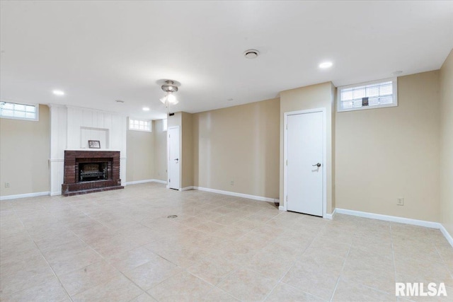 unfurnished living room featuring a brick fireplace and light tile patterned flooring