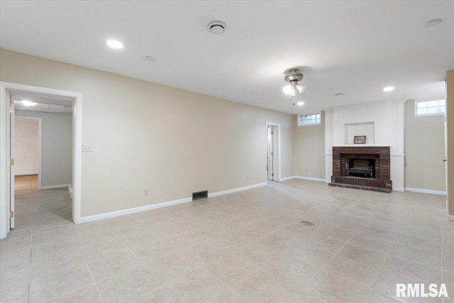 unfurnished living room with a fireplace and light tile patterned floors