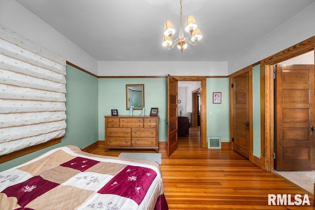 bedroom featuring a chandelier and hardwood / wood-style flooring