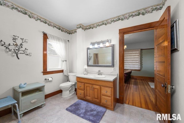 bathroom featuring vanity, toilet, and hardwood / wood-style flooring