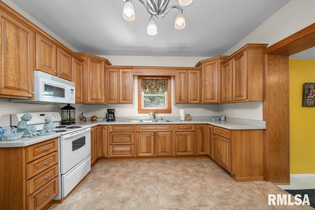 kitchen with a notable chandelier, hanging light fixtures, sink, and white appliances