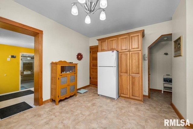 kitchen featuring an inviting chandelier and white fridge