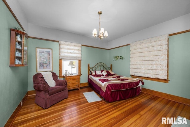 bedroom featuring an inviting chandelier and hardwood / wood-style flooring