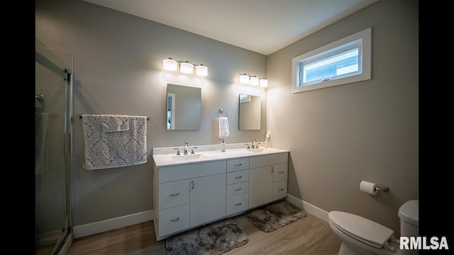 bathroom with vanity, hardwood / wood-style flooring, toilet, and a shower with door