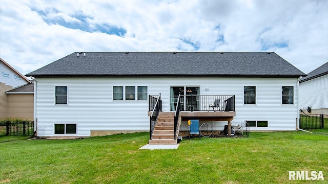 rear view of house featuring a lawn and a deck