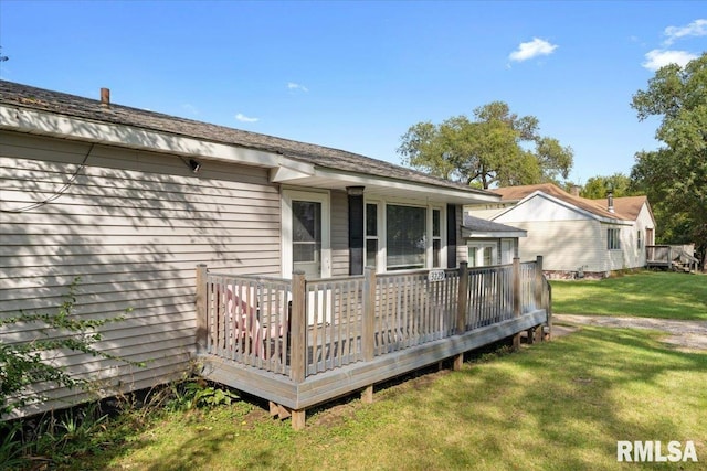 rear view of property with a deck and a yard