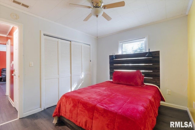 bedroom with ceiling fan, a closet, ornamental molding, and dark hardwood / wood-style flooring