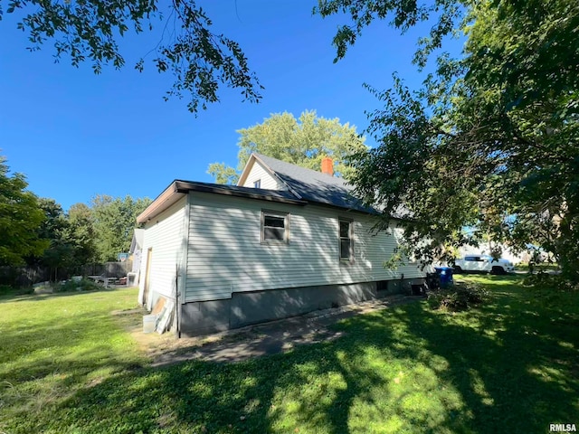 view of side of home with a yard