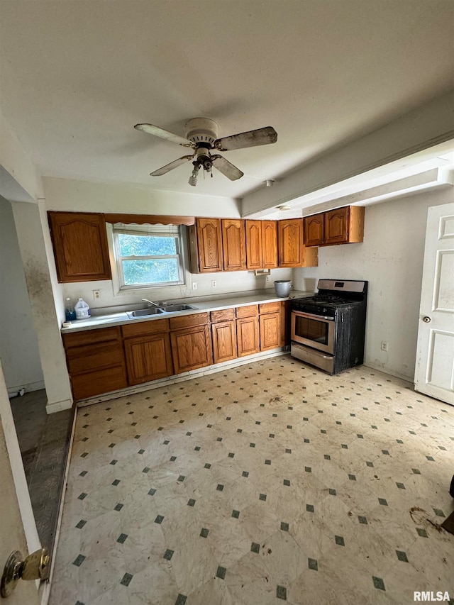 kitchen with ceiling fan, stainless steel range with gas stovetop, and sink