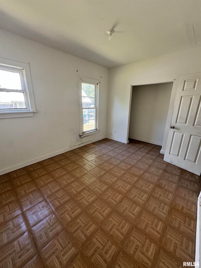 unfurnished bedroom featuring parquet flooring