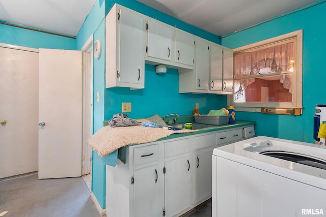 interior space with washer / dryer, white cabinetry, and sink