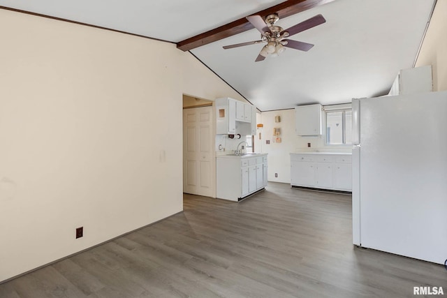 unfurnished living room with ceiling fan, lofted ceiling with beams, sink, and wood-type flooring