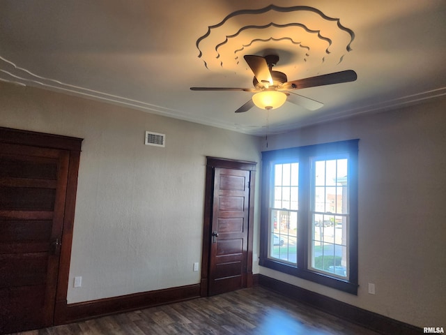 empty room with ceiling fan and dark wood-type flooring