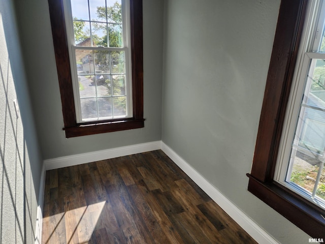 unfurnished room with dark wood-type flooring