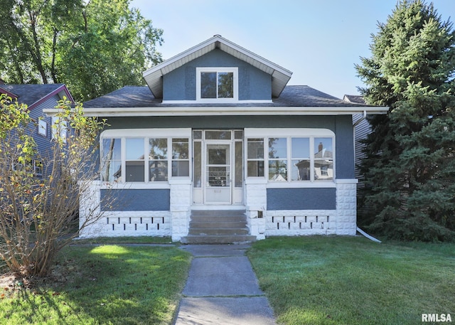 view of front of house with a sunroom and a front yard