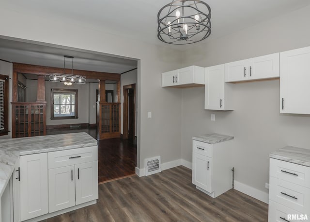 kitchen with a chandelier, white cabinetry, hanging light fixtures, and dark hardwood / wood-style floors