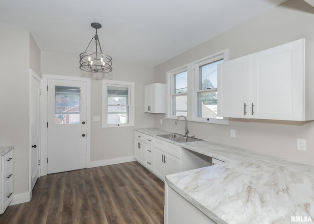 kitchen with a healthy amount of sunlight, white cabinetry, hanging light fixtures, and dark wood-type flooring