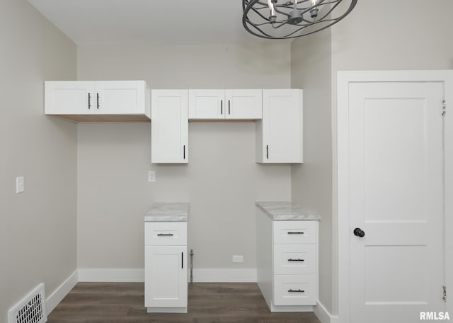 kitchen featuring white cabinets, an inviting chandelier, and dark wood-type flooring