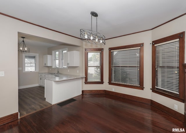 kitchen with white cabinets, crown molding, sink, dark hardwood / wood-style floors, and decorative light fixtures