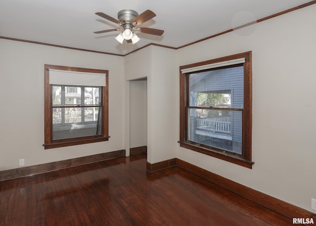 spare room featuring dark hardwood / wood-style flooring, ceiling fan, plenty of natural light, and ornamental molding