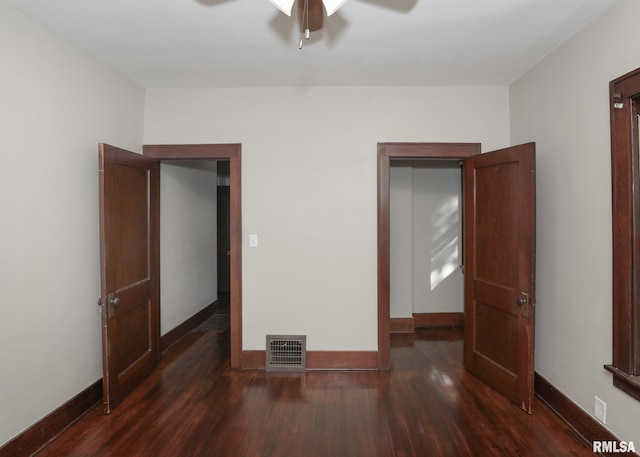 unfurnished bedroom featuring ceiling fan and dark wood-type flooring