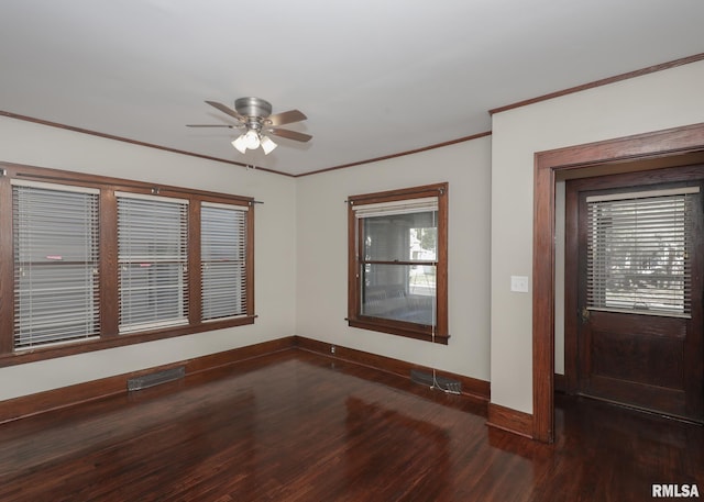 empty room featuring ceiling fan, dark wood-type flooring, and ornamental molding