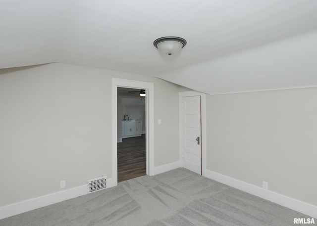 bonus room with sink, light colored carpet, and lofted ceiling