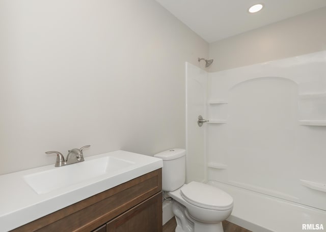 bathroom with walk in shower, vanity, and toilet