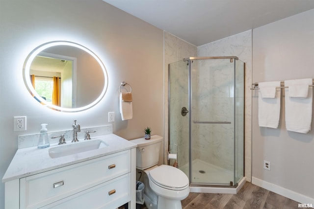 bathroom with vanity, a shower with shower door, toilet, and hardwood / wood-style flooring