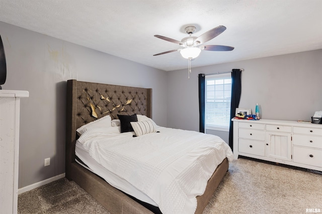 carpeted bedroom featuring ceiling fan and a textured ceiling