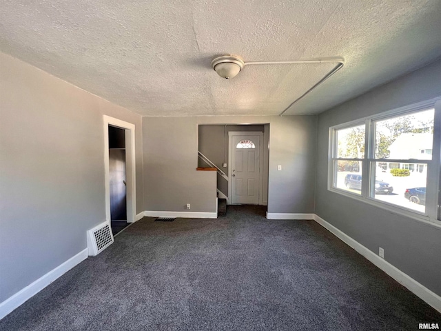 carpeted entrance foyer with a textured ceiling