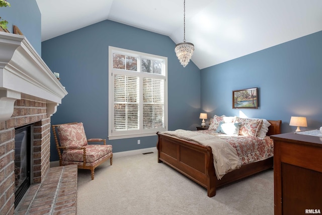 bedroom with a notable chandelier, vaulted ceiling, a brick fireplace, and carpet floors