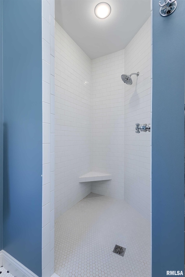 bathroom with tile patterned flooring and tiled shower