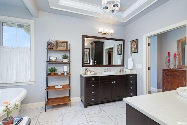 bathroom with vanity, ornamental molding, a tray ceiling, and a bathing tub