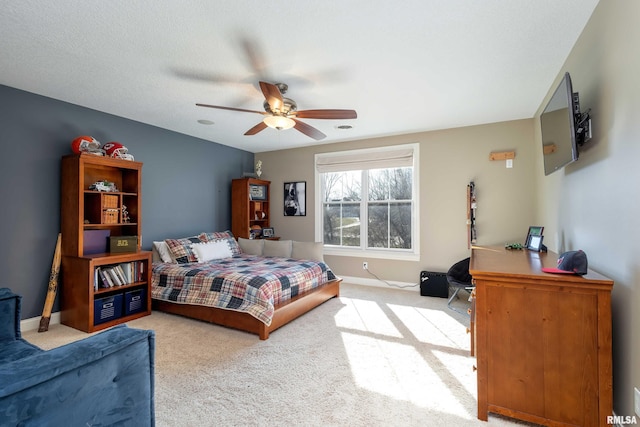 bedroom with ceiling fan, a textured ceiling, and light colored carpet