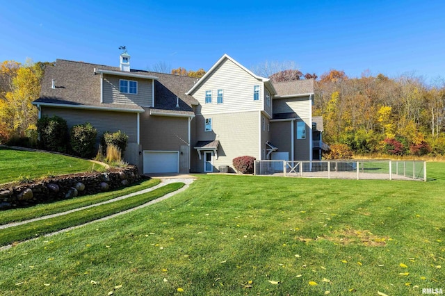 back of house featuring a lawn and a garage